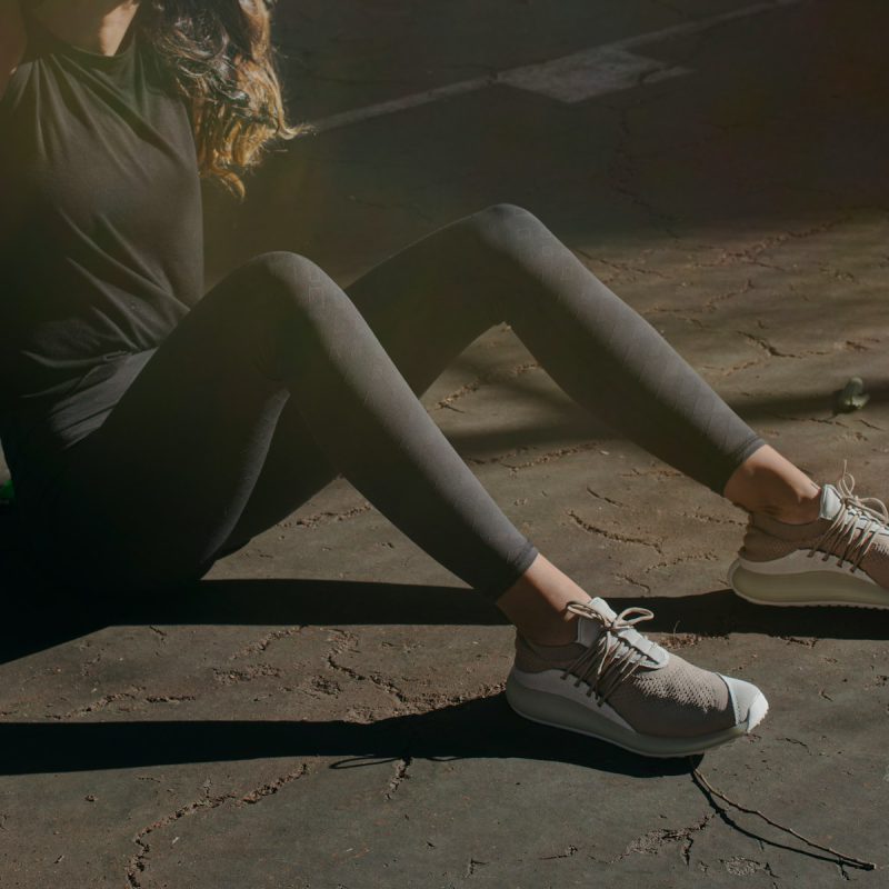 a woman sitting on the ground with her legs crossed